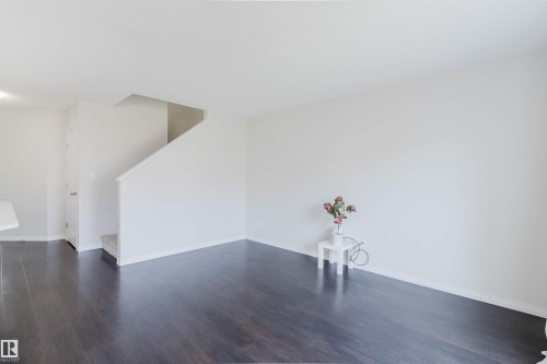 Open-concept living area with wood-finish flooring, white baseboards, and neutral wall paint - 2082 Price Landing, Edmonton, AB - Indoor Photo Showing Other Room