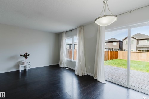 Spacious interior with dark wood-finish flooring, light neutral wall paint, and a contemporary ceiling fixture - 2082 Price Landing, Edmonton, AB - Indoor