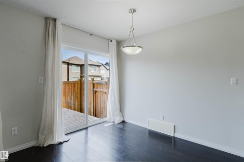 Spacious room featuring dark wood-finish flooring, light grey walls, and white trim - 2082 Price Landing, Edmonton, AB - Indoor Photo Showing Other Room