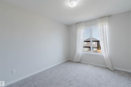 Bright room featuring light gray walls, a window with white trim, and light gray carpeting - 2082 Price Landing, Edmonton, AB - Indoor