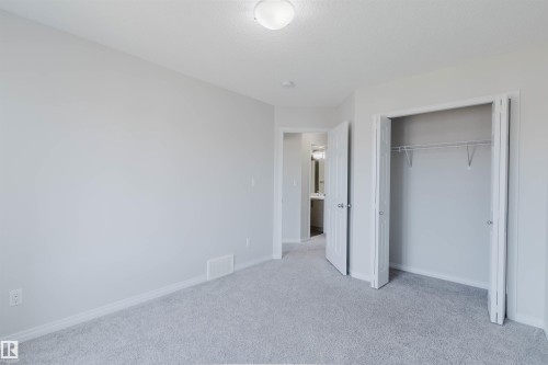 Light-colored carpeting in a neutral-toned room featuring a flush-mount ceiling light and white trim - 2082 Price Landing, Edmonton, AB - Indoor Photo Showing Other Room