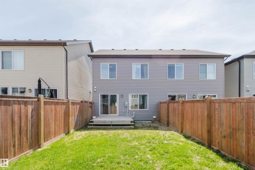 Rear exterior featuring gray siding, a wood deck, and a grass lawn - 2082 Price Landing, Edmonton, AB - Outdoor With Exterior