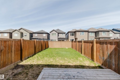 Expansive backyard featuring a rectangular lawn area and a light-toned wooden deck - 2082 Price Landing, Edmonton, AB - Outdoor