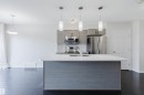 Kitchen island with white countertop, integrated sink, and three pendant lights - 2082 Price Landing, Edmonton, AB  - Indoor Photo Showing Kitchen With Stainless Steel Kitchen With Upgraded Kitchen 