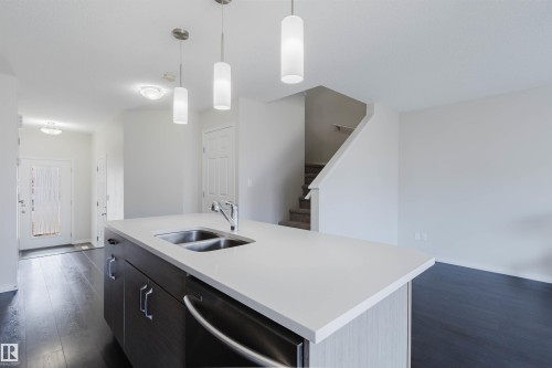 Kitchen island featuring a double-basin undermount sink, gooseneck faucet, and integrated dishwasher - 2082 Price Landing, Edmonton, AB - Indoor Photo Showing Kitchen With Double Sink
