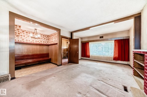 Dedicated alcove featuring built-in seating, wood paneling, and an overhead light fixture - 11929 91 Street, Edmonton, AB 
