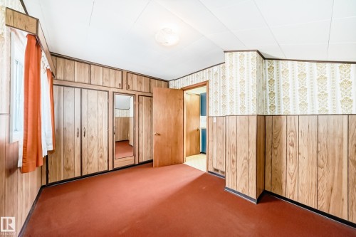 Room with wood-finish paneling and patterned wallpaper - 11929 91 Street, Edmonton, AB 