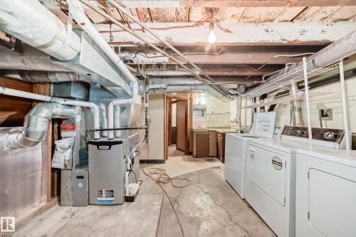 Utility area featuring a concrete floor, exposed ceiling beams, and overhead ductwork - 11929 91 Street, Edmonton, AB 