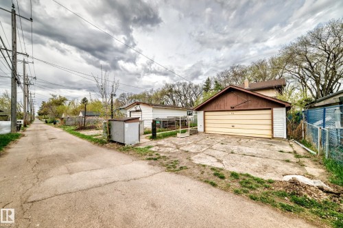 Detached two-car garage with a light-colored garage door and brown siding details, positioned behind the main residence - 11929 91 Street, Edmonton, AB 