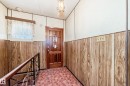 Entryway featuring wood-panel wainscoting, a paneled wood-finish door, and patterned tile flooring - 11929 91 Street, Edmonton, AB 