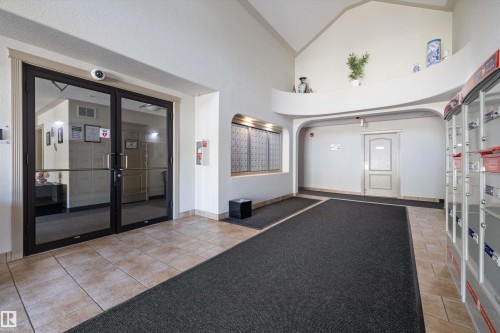Entrance foyer with social/meeting room on one side and postal boxes on the other side leading into the main hallway - 415 12550 140 Avenue, Edmonton, AB - Indoor Photo Showing Other Room