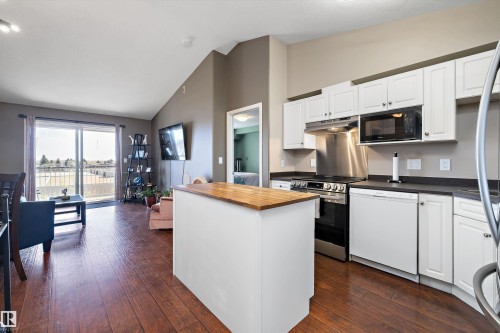 View of the living room and kitchen area with a sliding door to the south facing balcony. - 415 12550 140 Avenue, Edmonton, AB - Indoor Photo Showing Kitchen
