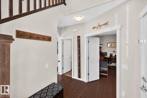 Entryway featuring wood-finish flooring, a built-in wood coat rack, and white trim - 8003 Summerside Grande Boulevard, Edmonton, AB - Indoor Photo Showing Other Room