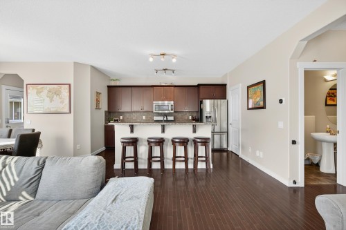 Open-concept living area featuring rich wood-finish flooring - 8003 Summerside Grande Boulevard, Edmonton, AB - Indoor