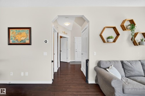 Arched entryway framing a hallway with dark wood-finish flooring - 8003 Summerside Grande Boulevard, Edmonton, AB - Indoor