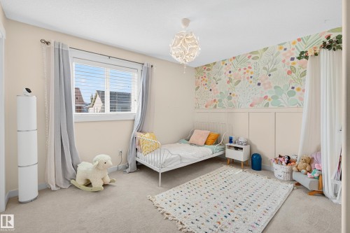 Soft neutral wall paint with a floral accent wall featuring board and batten detailing - 8003 Summerside Grande Boulevard, Edmonton, AB - Indoor Photo Showing Bedroom
