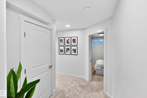 Hallway with light gray carpet, recessed lighting, white trim, and a white interior door with a brushed nickel handle - 8003 Summerside Grande Boulevard, Edmonton, AB - Indoor Photo Showing Other Room