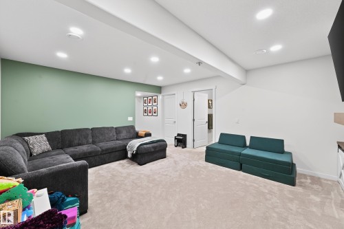 Spacious finished room featuring light beige carpeting, recessed lighting, and a green accent wall - 8003 Summerside Grande Boulevard, Edmonton, AB - Indoor Photo Showing Other Room