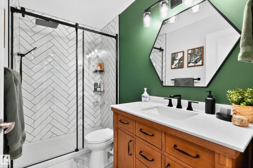 Modern bathroom featuring a wood-finish vanity with a white countertop and rectangular undermount sink - 8003 Summerside Grande Boulevard, Edmonton, AB - Indoor Photo Showing Bathroom