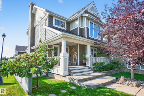 Contemporary siding exterior with a welcoming covered front porch, white railing, and concrete steps - 8003 Summerside Grande Boulevard, Edmonton, AB - Outdoor With Deck Patio Veranda