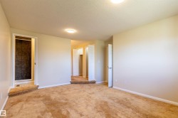 Carpeted room featuring a recessed shower with dark tile surround, multiple white doors, and flush-mount ceiling lighting - 