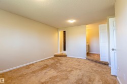 Plush brown carpet flooring and light-toned walls define this interior space - 
