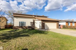 Exterior featuring light-colored siding, a brown brick facade, and an attached two-car garage - 