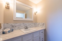 Bathroom vanity featuring a rectangular sink, single-handle chrome faucet, and a stone-patterned countertop - 