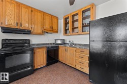 Kitchen featuring wood cabinetry, dark countertops, and tile flooring - 