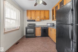 Kitchen featuring wood cabinetry, dark countertops, and tile flooring - 