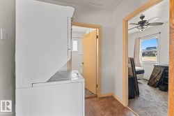 Dedicated laundry area featuring a white stacked washer and dryer - 