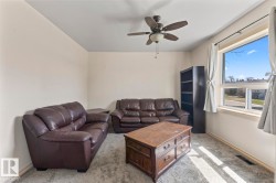 Bright room featuring a large window, neutral wall paint, and a ceiling fan with integrated lighting - 