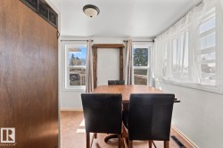 Bright interior space featuring multiple windows, a ceiling-mounted light fixture, and wood-finish flooring - 