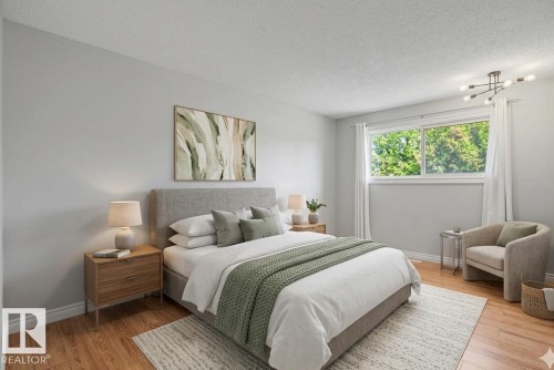 Spacious bedroom featuring wood-finish flooring, a large window, and a contemporary ceiling light fixture - 16715 79A Avenue, Edmonton, AB - Indoor Photo Showing Bedroom