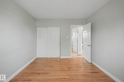 Room featuring wood-finish flooring, white baseboards, and light gray walls - 16715 79A Avenue, Edmonton, AB - Indoor Photo Showing Other Room