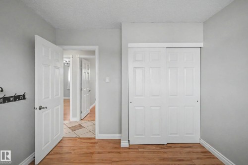Room featuring wood-finish flooring, light grey walls, and white baseboards - 16715 79A Avenue, Edmonton, AB - Indoor Photo Showing Other Room