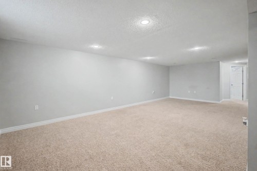 Spacious room featuring neutral carpeting, light-toned walls, recessed lighting, and white baseboards - 16715 79A Avenue, Edmonton, AB - Indoor Photo Showing Other Room