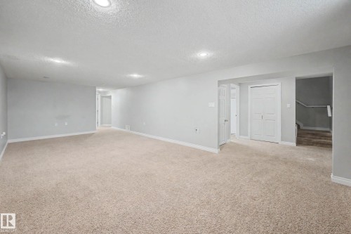 Spacious room featuring neutral carpeting, light gray walls, recessed lighting, white baseboards, and a white interior door - 16715 79A Avenue, Edmonton, AB - Indoor Photo Showing Other Room