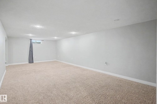 Spacious room featuring neutral carpeting, light gray painted walls, recessed ceiling lighting, and white baseboards - 16715 79A Avenue, Edmonton, AB - Indoor Photo Showing Other Room