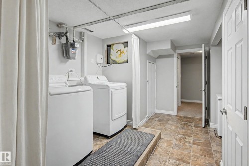 Dedicated laundry area featuring a washer and dryer, tile flooring, and overhead lighting - 16715 79A Avenue, Edmonton, AB - Indoor Photo Showing Laundry Room