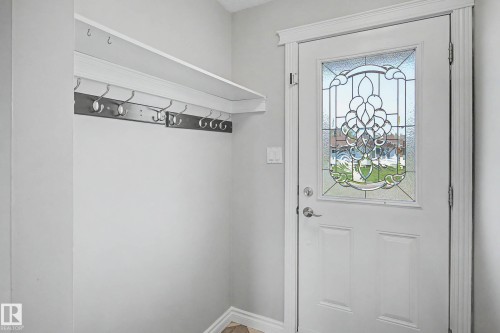 Entryway featuring a white door with decorative leaded glass, white trim, and light gray walls - 16715 79A Avenue, Edmonton, AB - Indoor Photo Showing Other Room