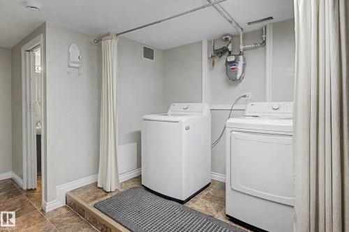 Dedicated laundry area featuring a washer and dryer, tile flooring, and light-toned walls - 16715 79A Avenue, Edmonton, AB - Indoor Photo Showing Laundry Room