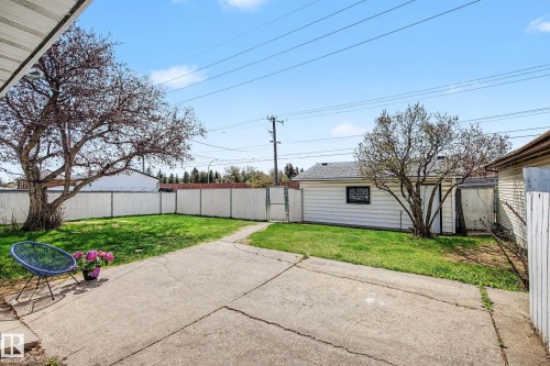 Expansive concrete patio area with a chain-link fence perimeter - 16715 79A Avenue, Edmonton, AB - Outdoor