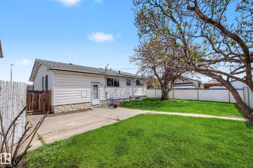 Expansive backyard featuring a manicured lawn, established trees, and a concrete patio - 16715 79A Avenue, Edmonton, AB - Outdoor
