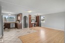 Open-concept living area featuring a kitchen with wood cabinetry and stainless steel appliances, complemented by light wood-finish flooring and tile flooring - 16715 79A Avenue, Edmonton, AB  - Indoor Photo Showing Kitchen 