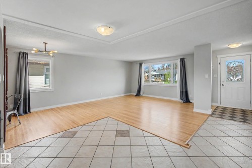 Open living area featuring wood-finish flooring and a tiled entryway - 16715 79A Avenue, Edmonton, AB - Indoor