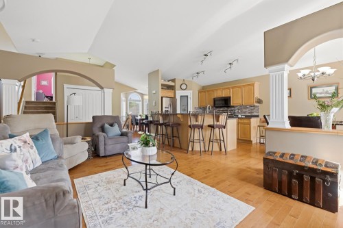 Expansive open-concept living space featuring wood-finish flooring and vaulted ceilings - 9 Danfield Place, Spruce Grove, AB - Indoor Photo Showing Living Room