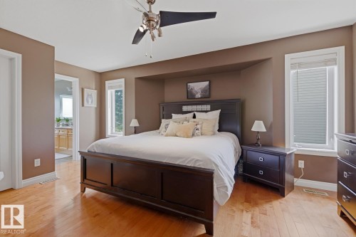 Bedroom with wood-finish flooring, recessed bed alcove, and a contemporary ceiling fan with integrated lighting - 9 Danfield Place, Spruce Grove, AB - Indoor Photo Showing Bedroom