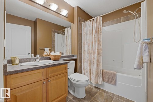 Bathroom featuring a vanity with wood cabinetry, a light-colored countertop, and a white integrated sink - 9 Danfield Place, Spruce Grove, AB - Indoor Photo Showing Bathroom