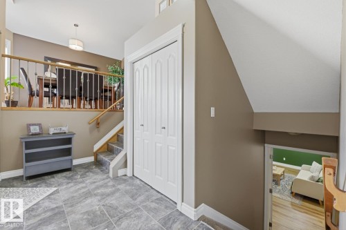 Foyer with gray tile flooring and bi-fold closet doors - 9 Danfield Place, Spruce Grove, AB - Indoor Photo Showing Other Room